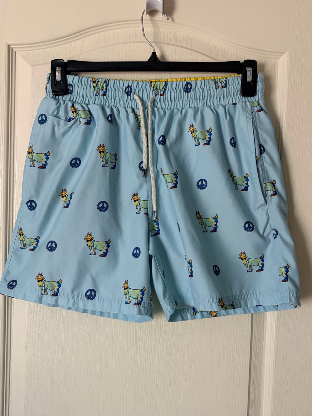 The GOAT USA Tahiti Hippie Peace Sign Swim Shorts, light blue, size Small